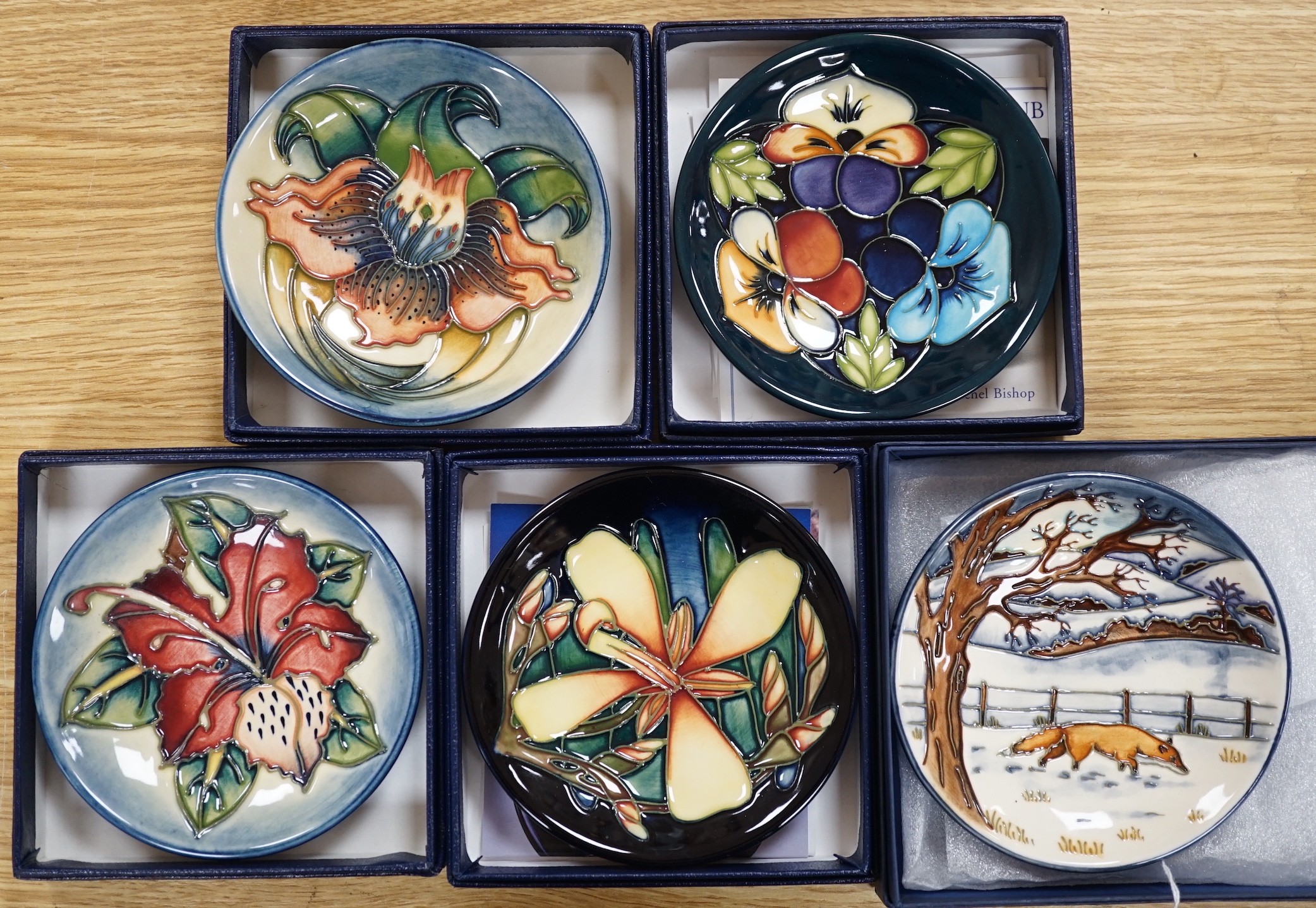 Six boxed Moorcroft pin dishes, A Woodside Farm, Panache, Simeon, Triple Choice, and Anna Lily. Each 11.5cm diameter